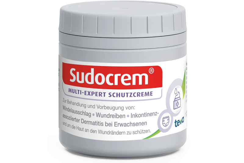 Sudocrem_tiegel_125g.png Grau-weiße Dose von Sudocrem mit rotem Logo und Informationen zur Verwendung der Schutzcreme.